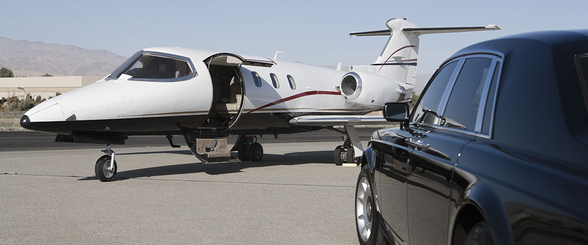 A car parked next to an airplane on the tarmac.