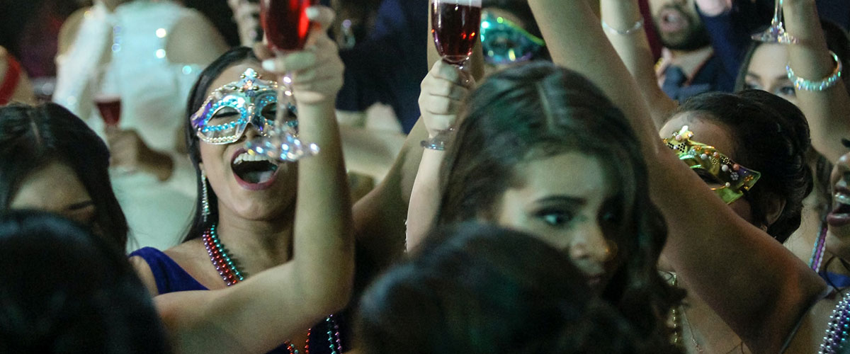 A group of people holding wine glasses in the air.